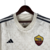 Camisa reserva da Roma 23/24 em cor creme com design de elementos arquitetônicos romanos. Detalhes em cinza carbono nas listras, escudo da Roma e logo Adidas bordados. Na nuca, destaque para a sigla 'ASR'.