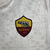 Camisa reserva da Roma 23/24 em cor creme com design de elementos arquitetônicos romanos. Detalhes em cinza carbono nas listras, escudo da Roma e logo Adidas bordados. Na nuca, destaque para a sigla 'ASR'.