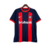 Camisa titular do San Lorenzo 2024-2025 azul marinho com duas faixas verticais vermelhas. Gola redonda e punhos vermelhos, ombros e mangas azul marinho. Escudo San Lorenzo com círculo central maior no peito esquerdo, logo Nike branco no direito.