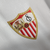 A camisa titular do Sevilla é branca com jacquard inspirado no escudo e cerâmicas de Sevilha. Gola em V com detalhes vermelhos, escudo à esquerda e logo da Castore em vermelho à direita.