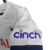 Camisa titular do Tottenham 2023-2024: Branca, punhos em azul, detalhes ondulados inspirados no N17, Swoosh Nike azul marinho no peito direito, escudo do Tottenham no peito esquerdo.