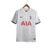 Camisa titular do Tottenham 2023-2024: Branca, punhos em azul, detalhes ondulados inspirados no N17, Swoosh Nike azul marinho no peito direito, escudo do Tottenham no peito esquerdo.