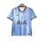 Camisa reserva do Tottenham 24/25 Nike azul clara com faixas e listras verticais. Escudo centralizado, logo Nike azul marinho. Elementos do universo criativo do rapper Travis Scott. Logos da sua gravadora Cactus Jack na camisa.