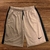 Shorts masculinos Nike Dry-Fit bordados em tom claro com detalhes em preto.