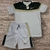 Conjunto masculino da Nike Dry-Fit, composto por camiseta branca com detalhes em verde e short branco, ambos com logo da Nike.