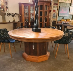 Mesa de jantar redonda em madeira de demolição, design exclusivo com pé oitavado, oferecendo charme e elegância para decorações sofisticadas.