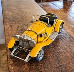 Carro conversível de metal amarelo, perfeito para adicionar sofisticação e charme à decoração de qualquer ambiente.