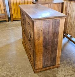 Cômoda rústica de 8 gavetas em madeira de demolição, com acabamento resistente e detalhes valorizando sua origem artesanal.