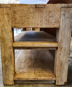 Rack baixo artesanal com duas gavetas e prateleiras, feito em madeira de demolição, proporcionando aconchego à decoração da sala.