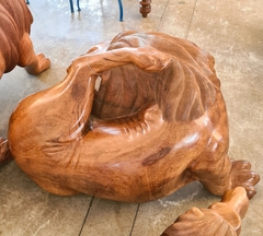 Escultura de leão coçando, esculpida em uma única peça de Angelim Pedra, destacando a habilidade artesanal e sustentabilidade.