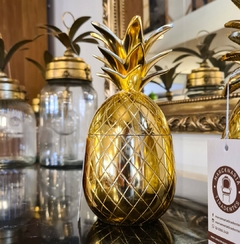Pote decorativo em formato de abacaxi, feito de metal dourado, ideal para decoração de ambientes internos e externos.