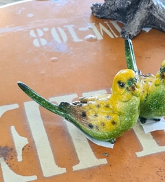 Pássaro artesanal de resina nas cores amarelo e verde, representando a qualidade e exclusividade da Marcenaria Tiradentes.