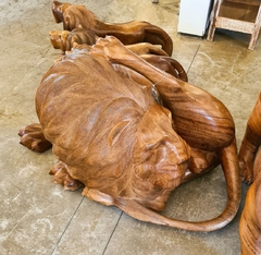 Escultura de leão coçando, esculpida em uma única peça de Angelim Pedra, destacando a habilidade artesanal e sustentabilidade.