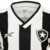 Detalhe da camisa Botafogo I 24/25 feminina, com listras em preto e branco e logo do clube.