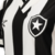 Detalhe da camisa feminina do Botafogo I 24/25, com listras brancas e pretas e escudo do clube.