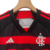 Conjunto infantil do Flamengo I 24/25 da Adidas, com camiseta preta e vermelha listrada e calção branco.