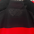 Conjunto infantil do Flamengo I 24/25 da Adidas, com camiseta preta e vermelha listrada e calção branco.