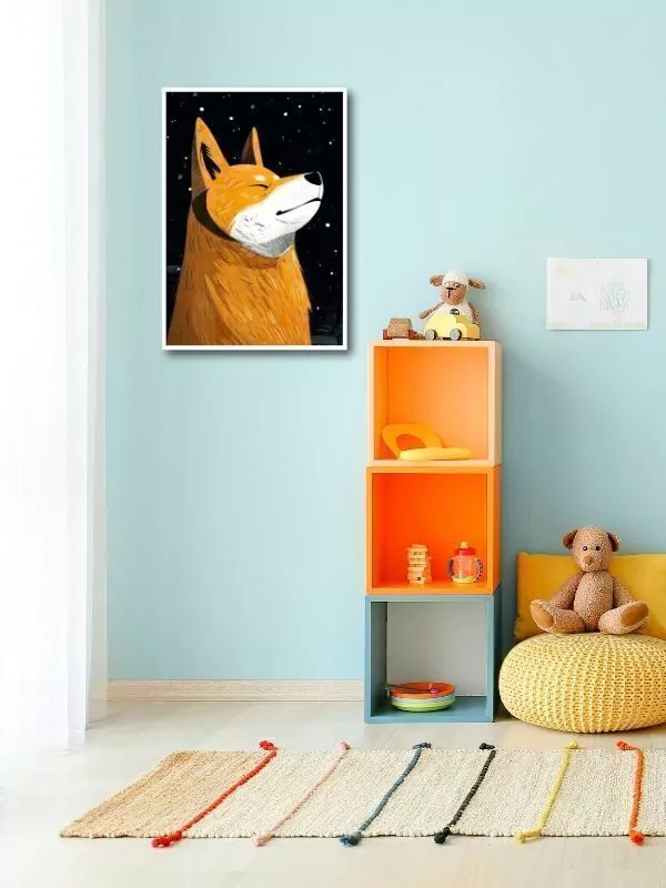 Quadro decorativo em uma parede azul claro de um quarto infantil, mostrando a imagem de um cão Shiba Inu sorridente com um fundo estrelado. O quadro é colocado acima de uma prateleira de brinquedos colorida, ao lado de uma área de brincar com tapetes de texturas diferentes e um puff amarelo.