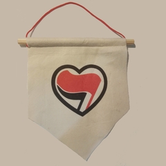 Flâmula de feltro, na cor bege, com a estampa: Coração com bandeira antifascista.