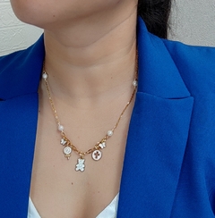 Collar con Perlas Nácar y cadena de acero inoxidable, acompañado con  dijes  de latón, en tono aperlado, componentes y terminales de chapa de oro, de un tamaño de 51cm aproximadamente.