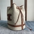 Celine Bucket Cuir Triomphe Bag in Textile": An elegant bucket bag from Celine, made from brown fabric with leather details, ideal for a sophisticated yet casual look.