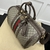 Gucci Savoy Small Duffle "Beige and Ebony GG Supreme" Travel Bag: A luxurious beige and brown Gucci travel bag featuring the iconic GG Supreme pattern and high-quality leather details.