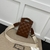 Gucci GG Matelasse Top Handle Mini Leather "Brown" Bag: A small bag in brown leather with a matelassé pattern and top handle from Gucci, perfect for sophisticated and modern looks.