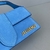 Bolsa Jacquemus Le Bambino Crossbody Flap Suede Light Blue: Uma bolsa crossbody de camurça azul claro, elegante e moderna para completar seu visual com um toque de sofisticação.