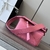 Bolsa Loewe Mini Puzzle Grained Calfskin em rosa: Uma pequena bolsa Loewe Puzzle em couro granulado rosa, com detalhes em couro marrom, exibindo um design único e moderno.