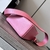 Loewe Mini Puzzle Grained Calfskin Bag in Pink: A small Loewe Puzzle bag in pink grained leather, with brown leather details, displaying a unique and modern design.