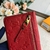 Carteira Louis Vuitton Key Pouch Monogram Empreinte Cerise em vermelho: um acessório vibrante e luxuoso para organizar suas chaves com elegância.