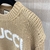 Suéter Gucci Wool With Intarsia Logo "Brown": Um suéter marrom da Gucci com logotipo entalhado em lã, para um visual sofisticado e distinto em dias mais frios.