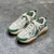 Tênis Amiri Bone Runner "White/Green": Calçado esportivo em branco com detalhes em verde, design moderno da marca Amiri.