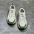 Tênis Amiri Bone Runner "White/Green": Calçado esportivo em branco com detalhes em verde, design moderno da marca Amiri.