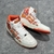 Amiri Skel Top Hi "White/Orange" Sneakers: White high shoes with orange details, modern design from the Amiri brand.