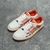 Amiri Skel Top Low "White/Orange" Sneakers: White low shoes with orange details, modern design from the Amiri brand.