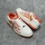 Amiri Skel Top Low "White/Orange" Sneakers: White low shoes with orange details, modern design from the Amiri brand.