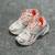 Balenciaga Runner White/Orange Sneakers: A pair of Balenciaga sneakers with orange details on a white background, perfect for a sporty and modern look.