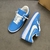 Tênis Louis Vuitton x Nike Air Force 1 Low By Virgil Abloh Light Blue: Um par de tênis na cor azul claro, parte da colaboração entre Louis Vuitton e Nike, desenhado por Virgil Abloh.