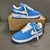 Tênis Louis Vuitton x Nike Air Force 1 Low By Virgil Abloh Light Blue: Um par de tênis na cor azul claro, parte da colaboração entre Louis Vuitton e Nike, desenhado por Virgil Abloh.