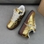 Louis Vuitton x Nike Air Force 1 Low By Virgil Abloh Metallic Gold Sneakers: A pair of metallic gold sneakers, part of the collaboration between Louis Vuitton and Nike, designed by Virgil Abloh.