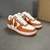 Louis Vuitton x Nike Air Force 1 Low By Virgil Abloh Orange/White Sneakers: A pair of orange and white sneakers, the result of a collaboration between Louis Vuitton and Nike with an exclusive design by Virgil Abloh.