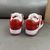 Tênis Louis Vuitton x Nike Air Force 1 Low By Virgil Abloh Red/White: Um par de tênis em vermelho e branco, parte da colaboração entre Louis Vuitton e Nike, criada por Virgil Abloh.