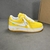 Louis Vuitton x Nike Air Force 1 Low By Virgil Abloh Yellow Sneakers: A pair of yellow sneakers from the collaboration between Louis Vuitton and Nike, designed by Virgil Abloh.