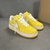 Louis Vuitton x Nike Air Force 1 Low By Virgil Abloh Yellow Sneakers: A pair of yellow sneakers from the collaboration between Louis Vuitton and Nike, designed by Virgil Abloh.