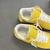 Louis Vuitton x Nike Air Force 1 Low By Virgil Abloh Yellow Sneakers: A pair of yellow sneakers from the collaboration between Louis Vuitton and Nike, designed by Virgil Abloh.