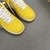 Louis Vuitton x Nike Air Force 1 Low By Virgil Abloh Yellow Sneakers: A pair of yellow sneakers from the collaboration between Louis Vuitton and Nike, designed by Virgil Abloh.