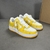 Louis Vuitton x Nike Air Force 1 Low By Virgil Abloh Yellow/White Sneakers: A pair of yellow and white sneakers, the result of a collaboration between Louis Vuitton and Nike with an exclusive design by Virgil Abloh.