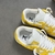 Louis Vuitton x Nike Air Force 1 Low By Virgil Abloh Yellow/White Sneakers: A pair of yellow and white sneakers, the result of a collaboration between Louis Vuitton and Nike with an exclusive design by Virgil Abloh.