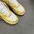 Louis Vuitton x Nike Air Force 1 Low By Virgil Abloh Yellow/White Sneakers: A pair of yellow and white sneakers, the result of a collaboration between Louis Vuitton and Nike with an exclusive design by Virgil Abloh.